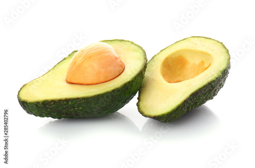 Halves of ripe avocado on white background