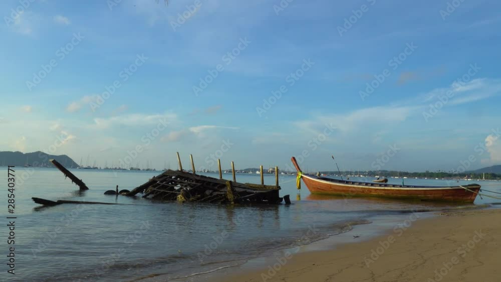 the waves wreck the ship ruins sunk on the beach at Chalong beach the waves wreck the ship ruins sunk on the beach at Chalong beach