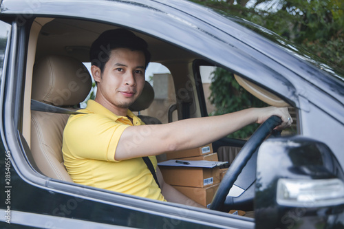 Young Asian Delivery man driving van to delivering packages
