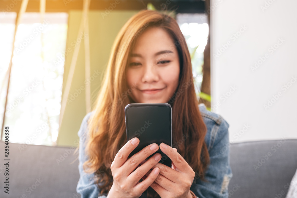 Closeup image of a beautiful asian woman holding , using and looking at smart phone Closeup image of a beautiful asian woman holding , using and looking at smart phone