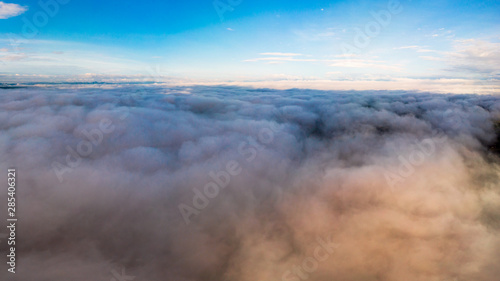 View from a drone flying over a cloud in the morning With the mountainous environment.