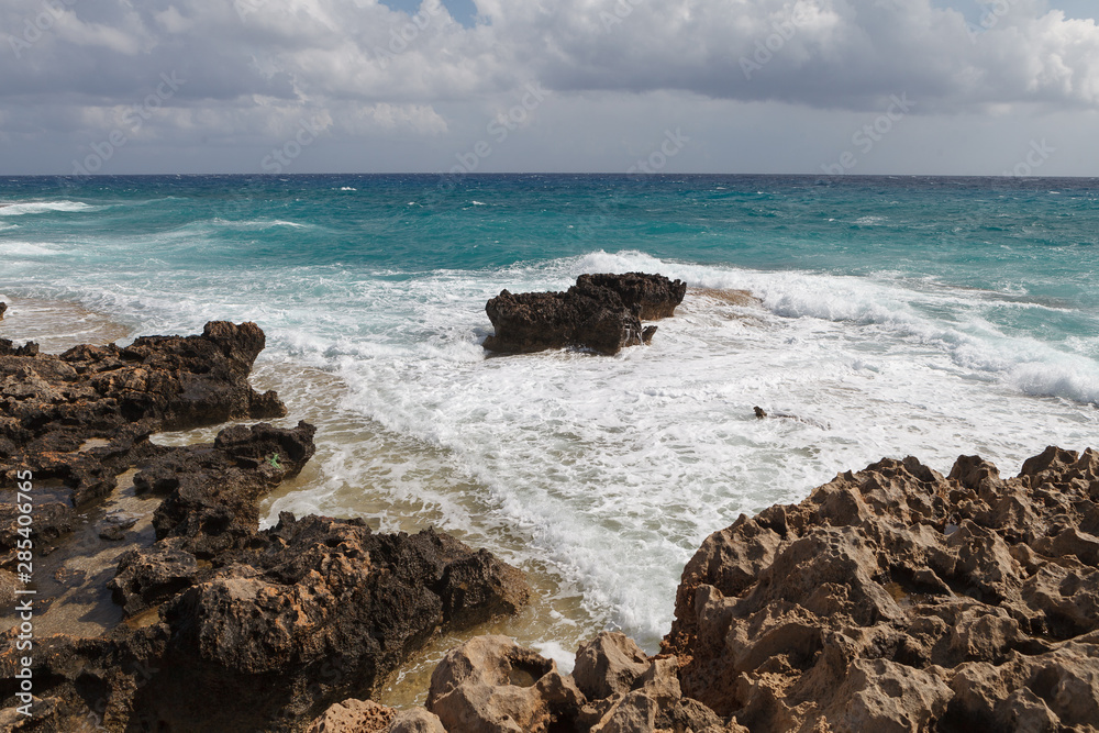 Rocky sea shore with splaches of waves. Cyprus - Mediterranean Sea coast.
