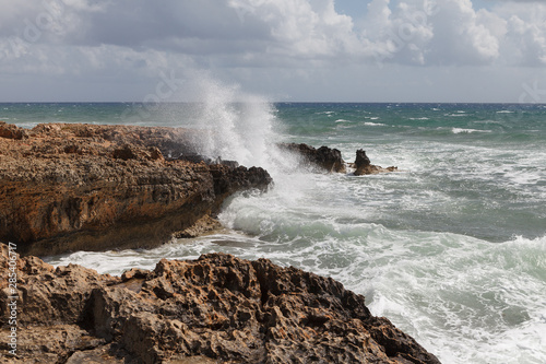 Rocky sea shore with splaches of waves. Cyprus - Mediterranean Sea coast.