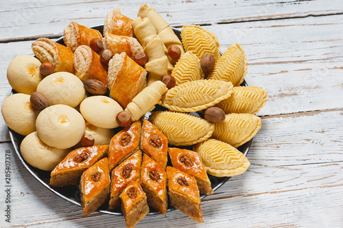 Traditional shekerbura,mutaki,shirinchorek,kata and pakhlava as Novruz symbol on xoncha on white background Azerbaijan holiday photo