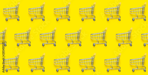 Obraz na plátně Shopping trolley on a yellow background
