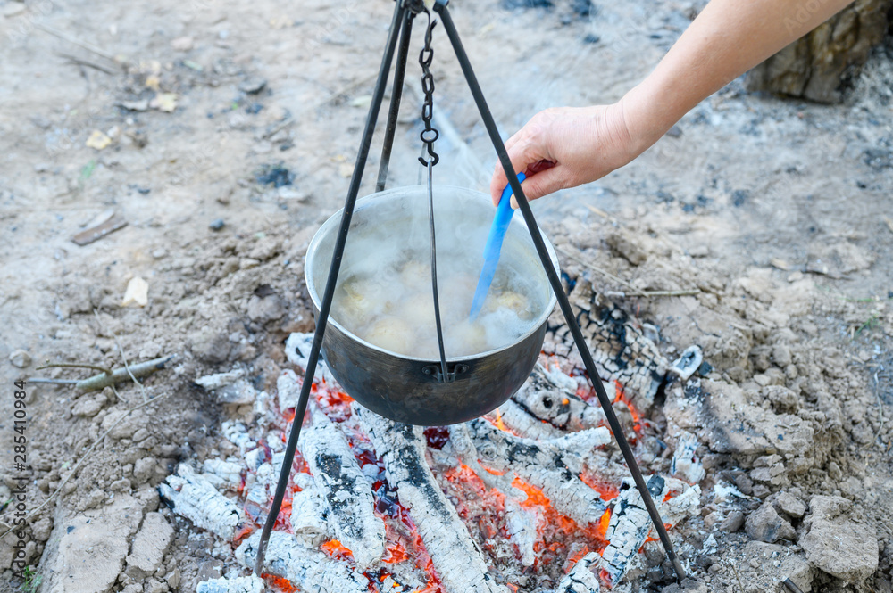 potatoes are cooked in a pot over the fire potatoes are cooked in a pot over the fire