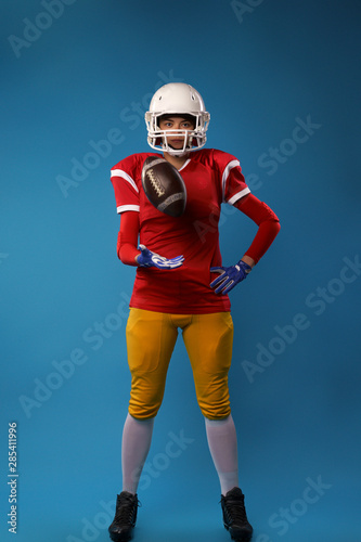 Photo of full length american football player in studio