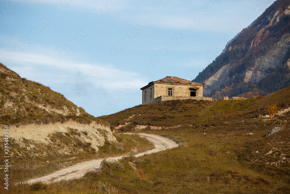 Photo of house at foot of mountain, picturesque mountain area and cloudy sky