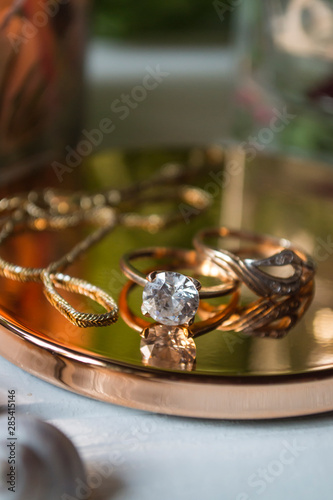 Golden ring with diamonds. Female jewelry on a table, close up.