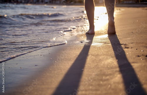 A man walking along the beach during sunset, blurred background