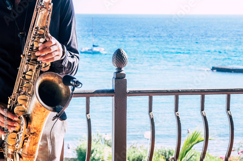 Photography closeup of music artist saxophonist  touching his instrument in the restaurant o