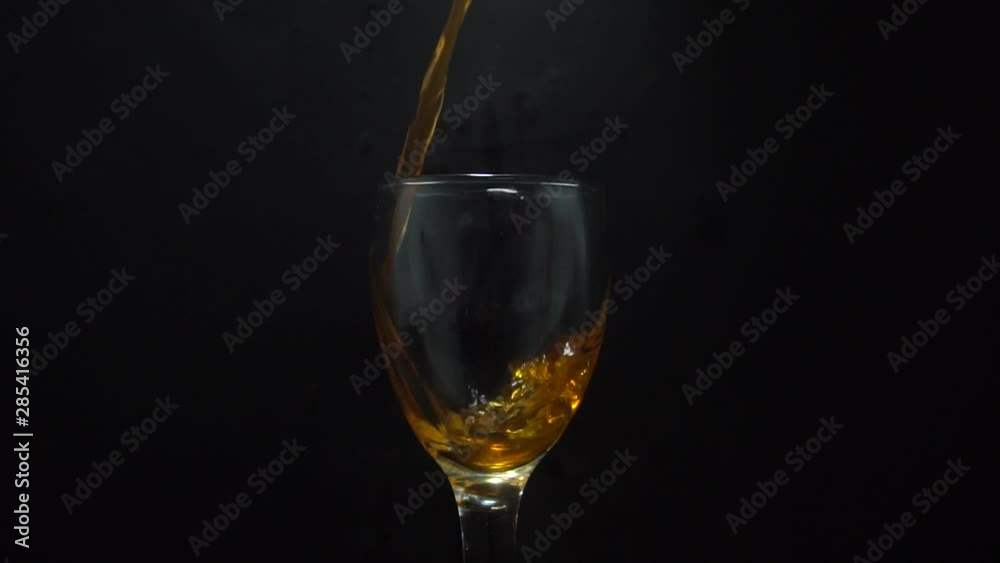 Pouring Fresh Orange juice in wmpty glass isolated on black background Pouring Fresh Orange juice in wmpty glass isolated on black background