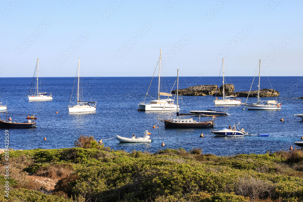 Blue sea, yachts and boats on Binibequer beach, Binibeca Vell, Menorca, Spain