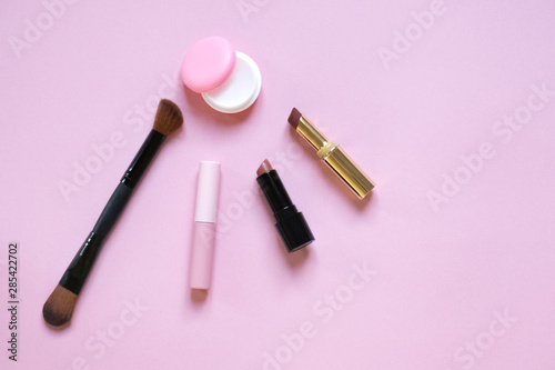 Beautiful flat lay of cosmetics and women's accessories on pink with place for text. Beauty, makeup, femininity, fashion concept