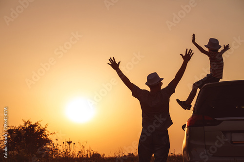 Father and son playing in the park at the sunset time.