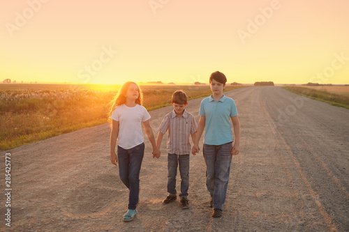 Children go on the road to meet the sunset.