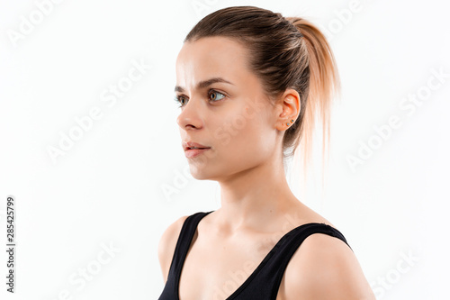 Young sporty blond woman in a black sportswear exercising isolated over white background.