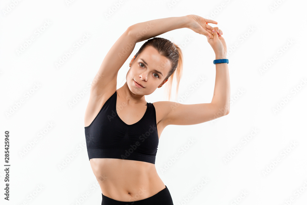 Young sporty blond woman in a black sportswear stretching before exercising isolated over white background. Young sporty blond woman in a black sportswear stretching before exercising isolated over white background.
