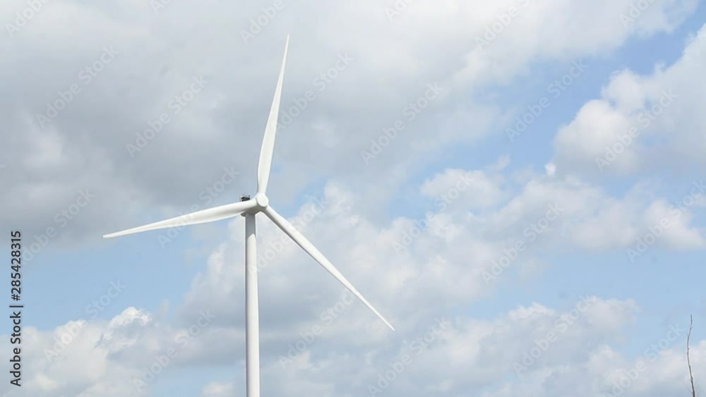 Spinning windmill against cloudy blue sky Spinning windmill against cloudy blue sky