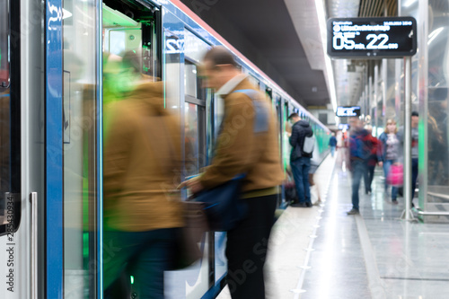 Passenger flow concept. People go on subway train. Passengers are blurred, movement is shown. Train station.