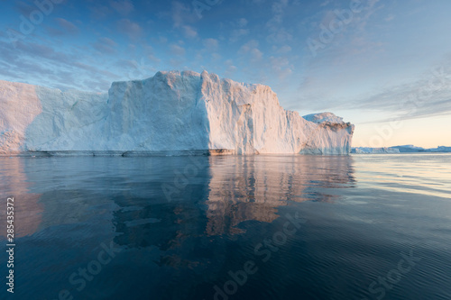 Nature and landscapes of Greenland or Antarctica. Travel on the ship among ices. Studying of a phenomenon of global warming Ices and icebergs of unusual forms and colors Beautiful midnight sun on ship © Michal