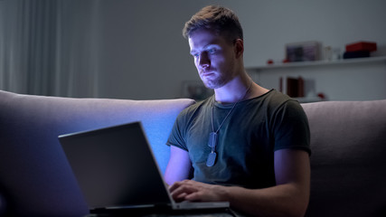 Serviceman searching job on laptop at home, adapting to civilian life after army