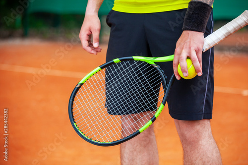 Closeup male tennis player holding racket and ball. © Dmytro Panchenko