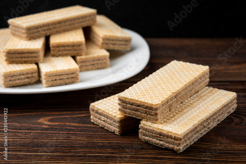 Vanilla wafer biscuit on dark wooden background.