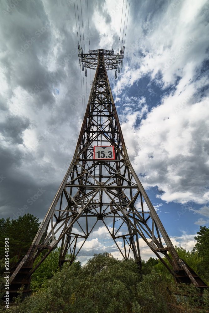 power line mast against blue sky with white clouds, close-up power line mast against blue sky with white clouds, close-up
