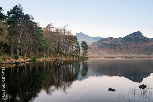 Fototapeta Naklejka Na Ścianę i Meble -  Beautiful Autumn Fall colorful sunrise over Blea Tarn in the Lake District with High Raise and The Langdales in the distance