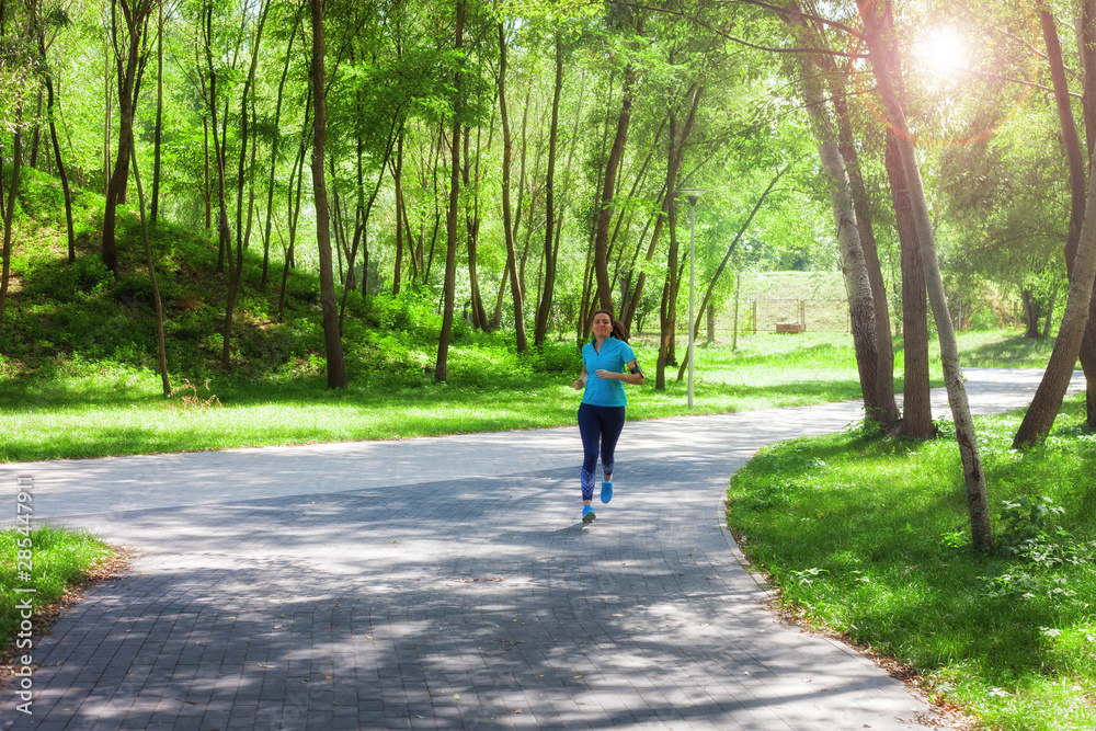 Fototapeta premium Fitness sporty woman jogger running at outdoors jogging track in park