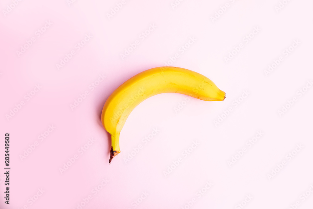 Flat composition of sweet banana on pink background with copy space for your text.