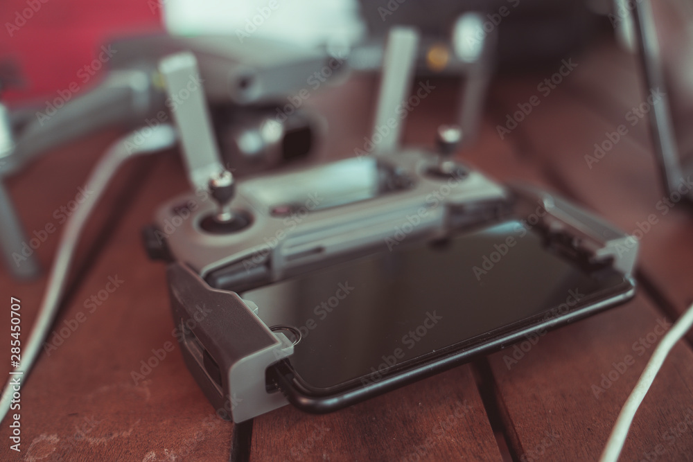 Drone quadcopter with a flight controller and notebook on the old wooden table. Drone quadcopter with a flight controller and notebook on the old wooden table.