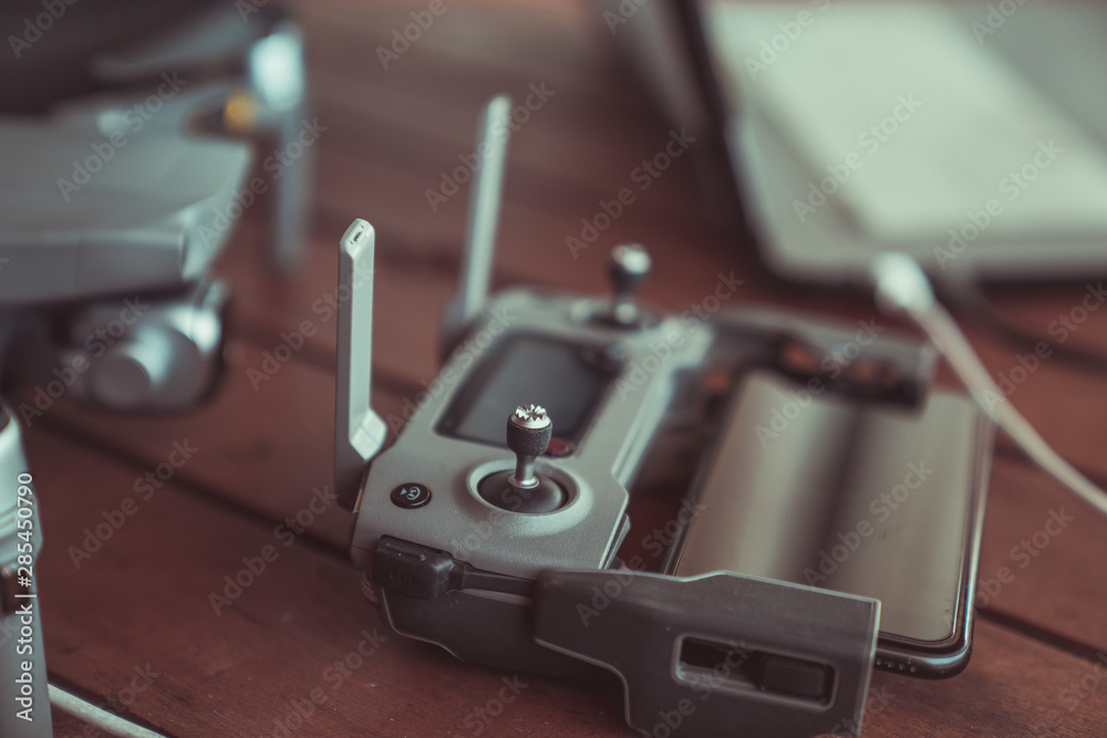 Drone quadcopter with a flight controller and notebook on the old wooden table. Drone quadcopter with a flight controller and notebook on the old wooden table.