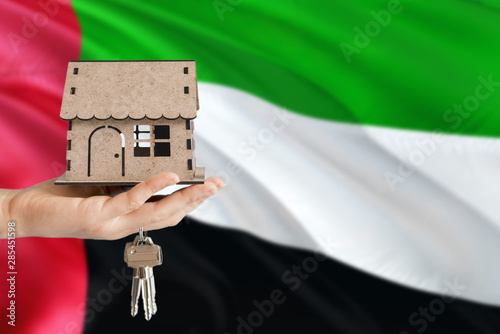 Canvas Print Woman hand holding wooden house and keys with hand
