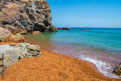 Fototapeta Naklejka Na Ścianę i Meble -  Thiorichia beach or Paliorema - the abandoned sulfur mines - where the rocks, due to the presence of sulphur, are red, orange and yellow
