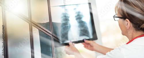 Female doctor looking at x-ray; multiple exposure