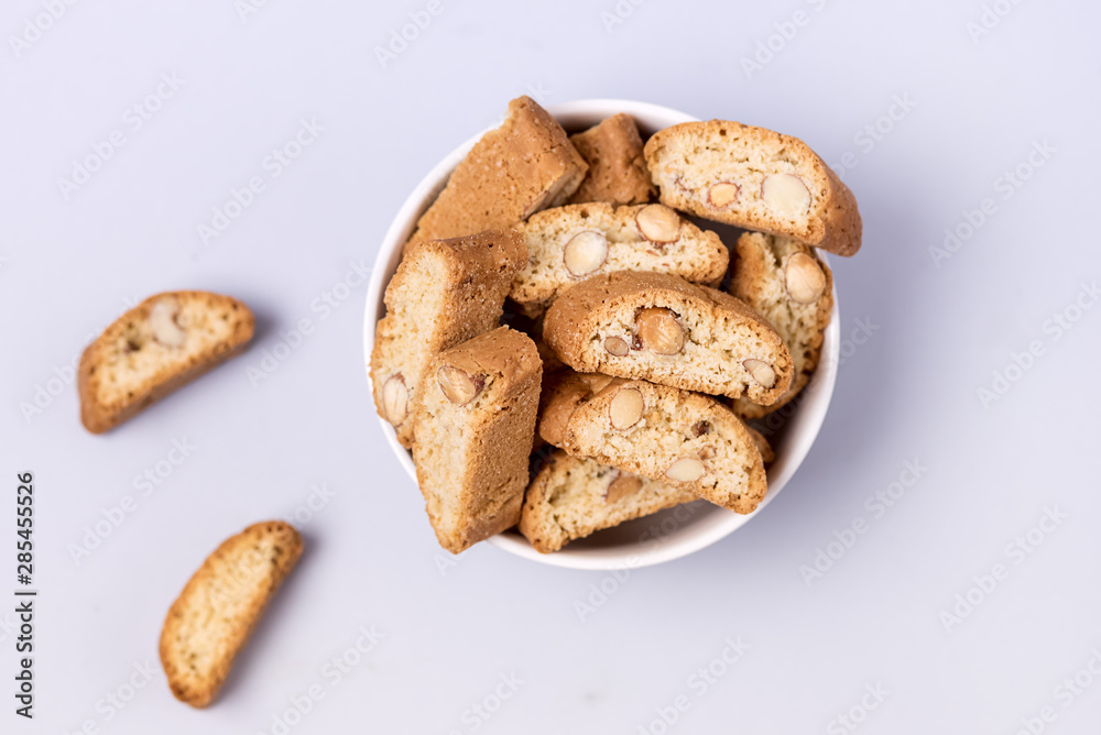 Italian Almond Biscuit Biscotti or Cantuccini in a White Bowl Tasty Italian Dessert for Coffee or Wine Top View Blue Background
