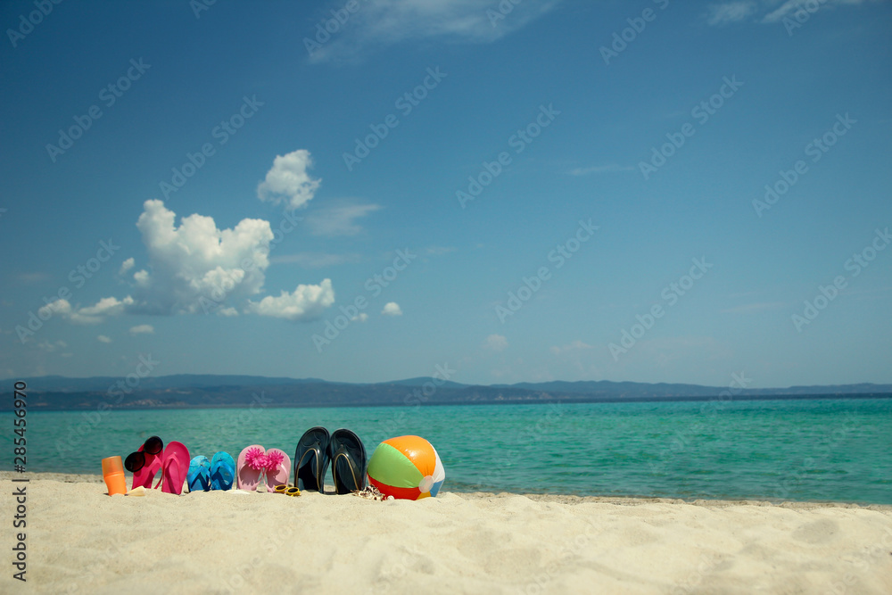 Family slippers on the sand on the beach Family slippers on the sand on the beach