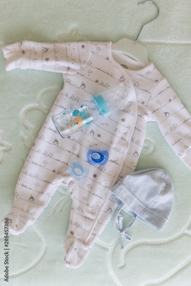 top view of newborn baby clothes with milk bottle. top view of newborn baby clothes with milk bottle.