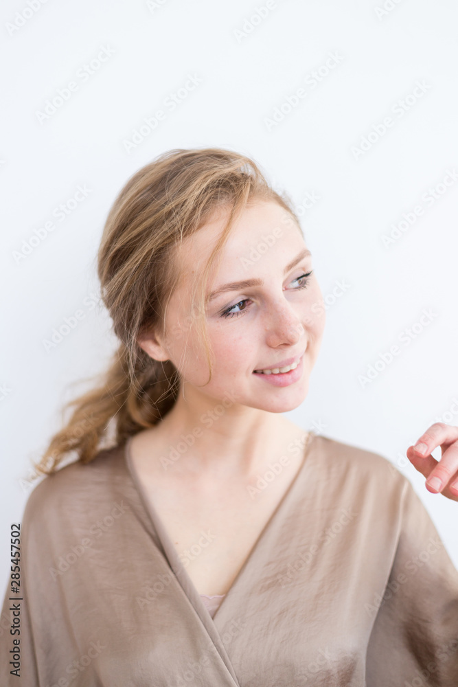 Attractive, beautiful young girl with brown hair on a white background. The concept of student life, youth. Attractive, beautiful young girl with brown hair on a white background. The concept of student life, youth.