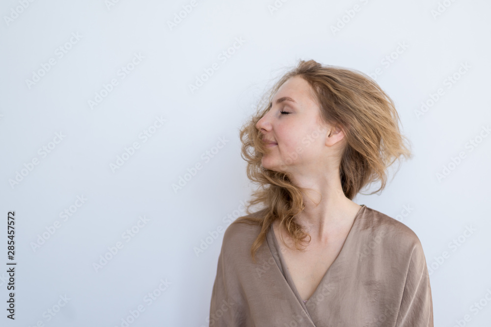 Portrait of a young beautiful girl who waves hair on a white background. Portrait of a young beautiful girl who waves hair on a white background.