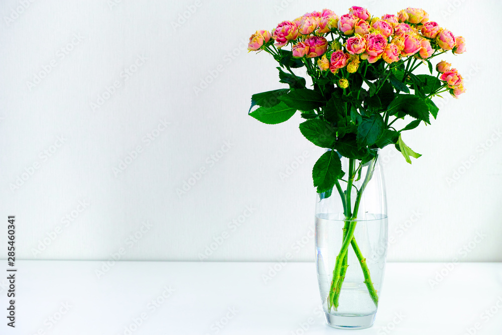 Fototapeta premium Bouquet of pink spray peony roses in vase on white table.