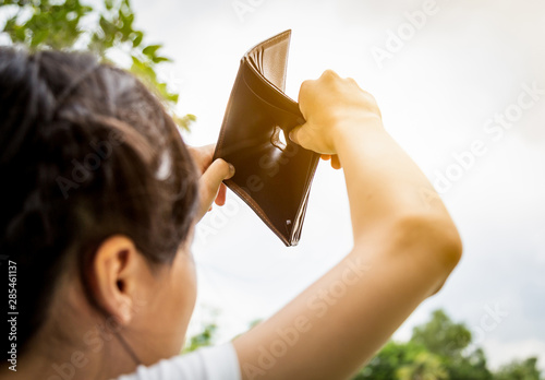 Fotografie Closeup asian child girl shows her wallet,hand open an empty wallet, no pocket m