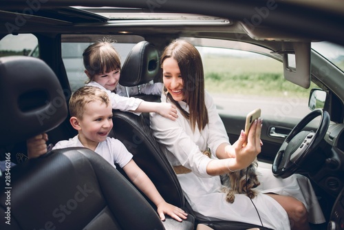 Mother with two children and a dog traveling by car