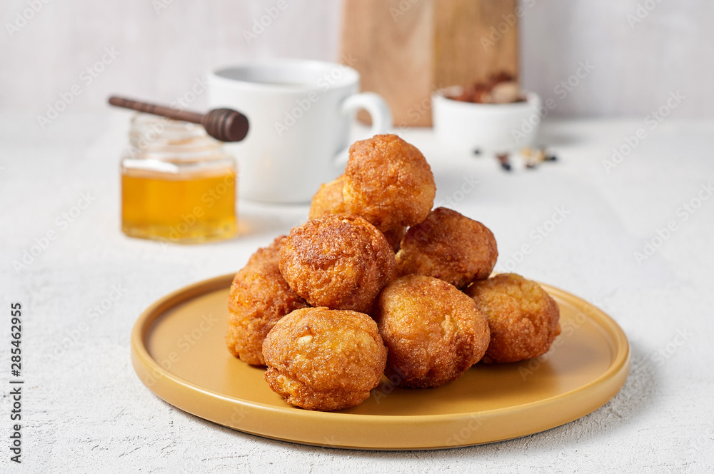 Cottage cheese balls doughnuts is jam-packed with jelly filling, cup of tea and honey