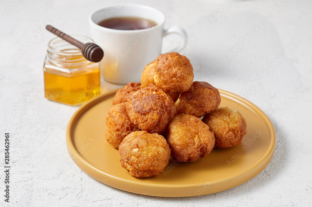 Cottage cheese balls doughnuts is jam-packed with jelly filling, cup of tea and honey