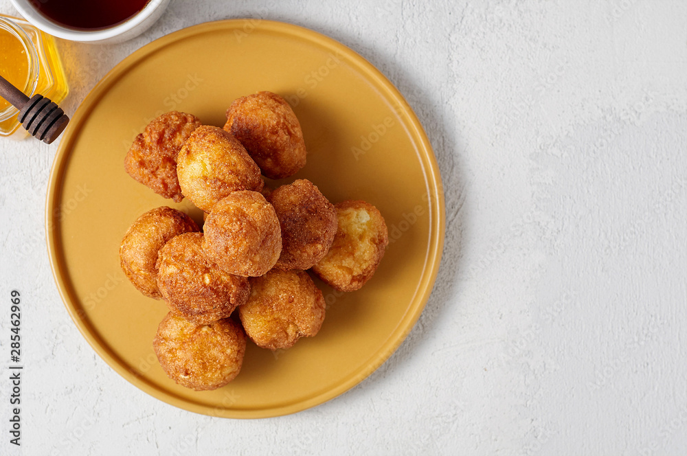 Cottage cheese balls doughnuts is jam-packed with jelly filling, cup of tea and honey