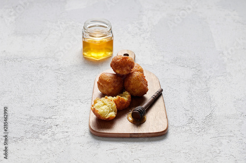 Obraz na płótnie Cottage cheese balls doughnuts is jam-packed with jelly filling on wooden cut board and glass jar honey w salonie