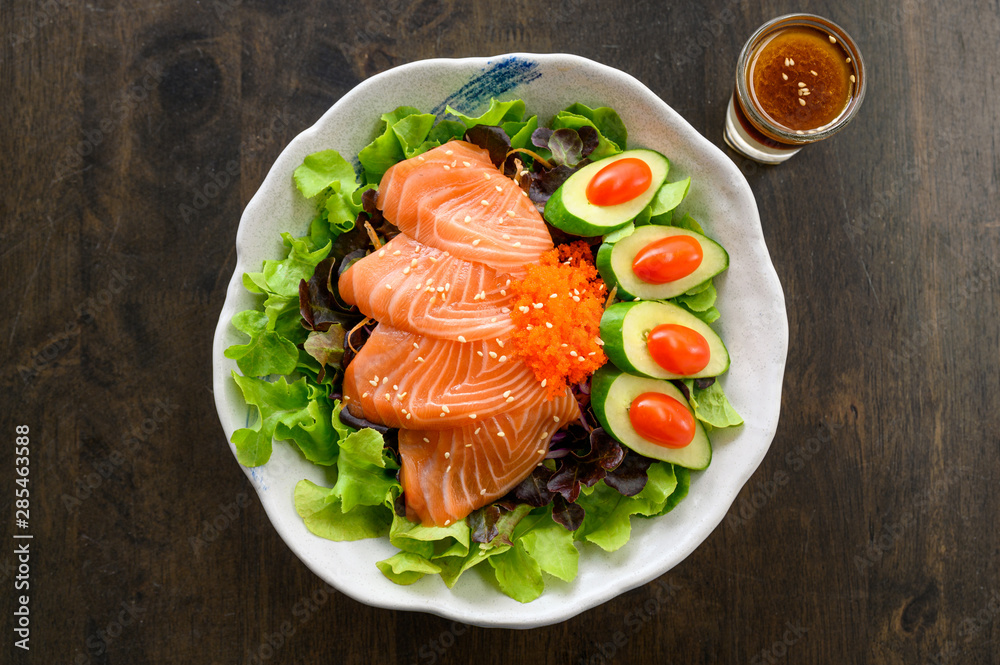 Raw Salmon sashimi with vegetable in ceramic bowl